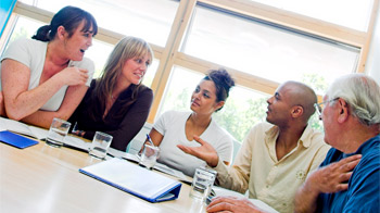 Group of five volunteers meeting as trustees indoors