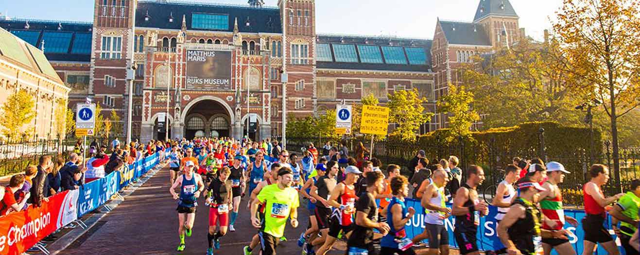Charity runners participating in the Amsterdam marathon oinf front of the Rijksmuseum.