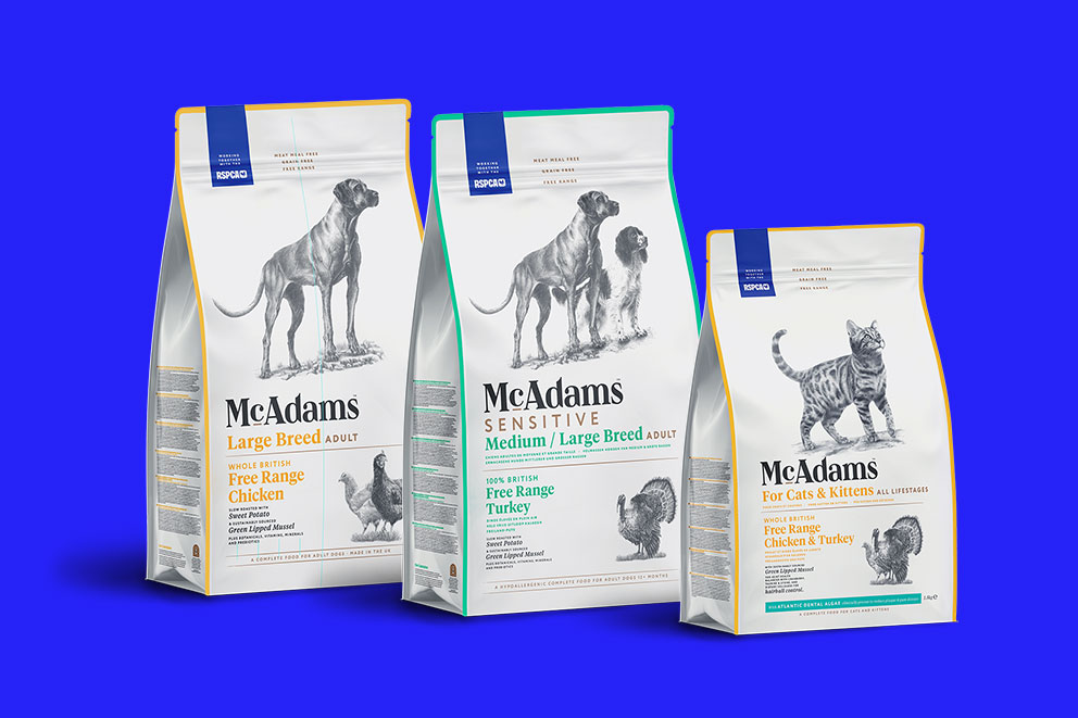 Three packets of McAdams pet food, left to right: for large dogs, medium dogs, and cats and kittens.