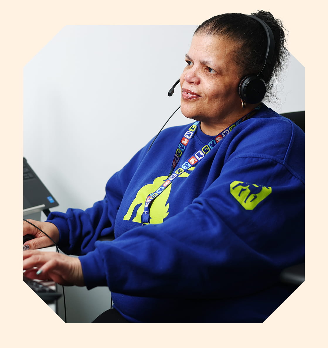 An RSPCA staff member wearing a headset working on a computer.