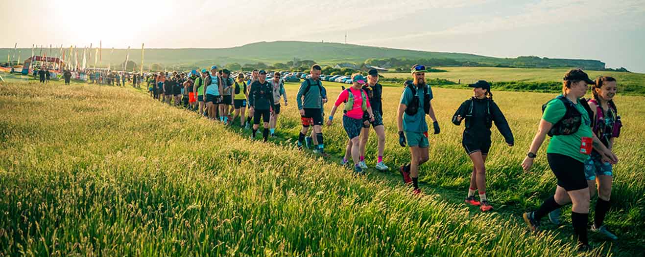 A large group of charity fundraisers set off across the fields.
