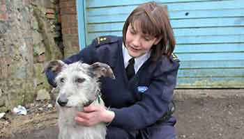 female rspca inspector with dog in front of closed garage
