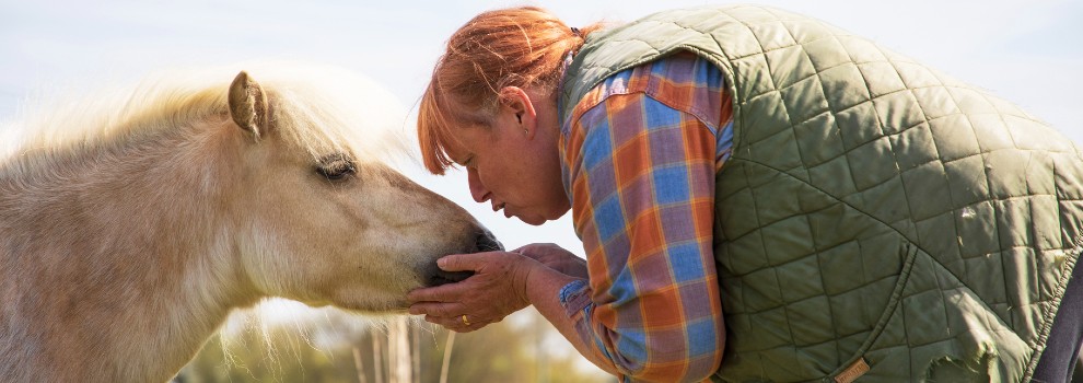 woman bowing down to kiss horse's nose © RSPCA