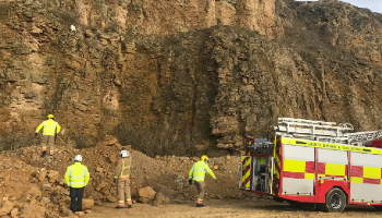 Goat up cliff with fire services below