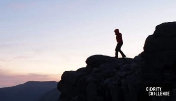 hiker on top of a mountain ledge at sunrise © RSPCA