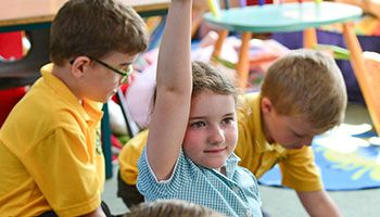 school girl raising her hand in class © RSPCA