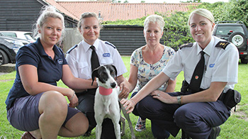 three rspca workers kneeling down with dog and owner outside © RSPCA