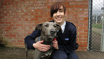 smiling rspca inspector with black dog