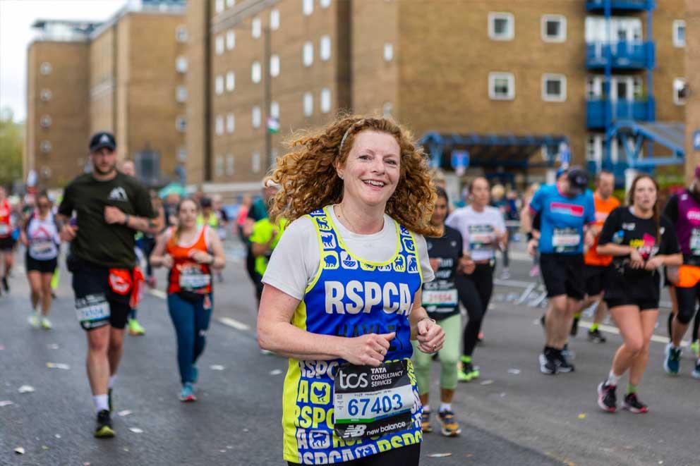 Female runner supporting the RSPCA and wearing a Team Animal running vest at organised charity run in London.