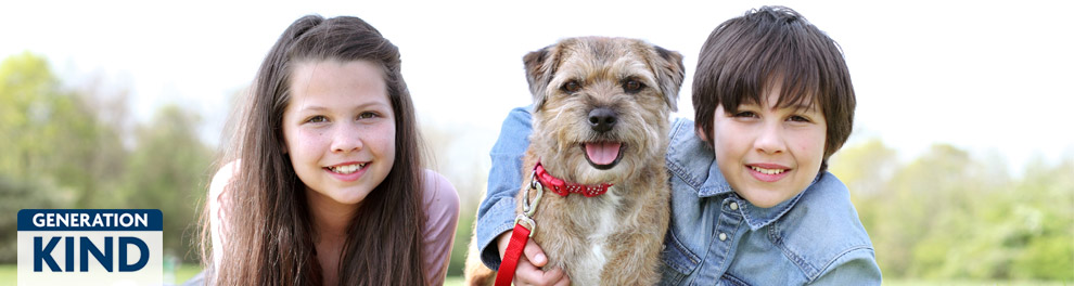 Girl and a boy outside in a field with a dog © RSPCA photolibrary