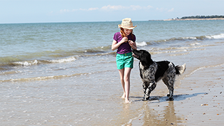 Girl with dog on the beach