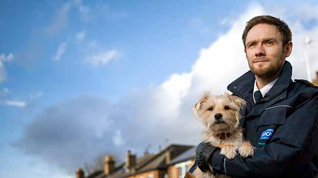 Inspector holding rescued dog